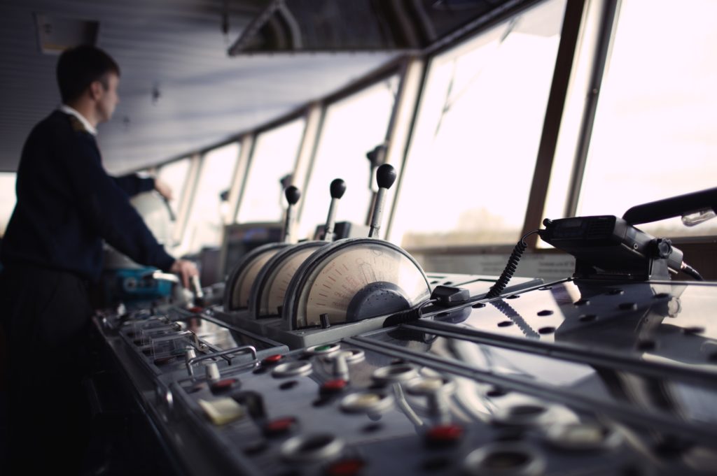 Navigation officer driving ship on the river.